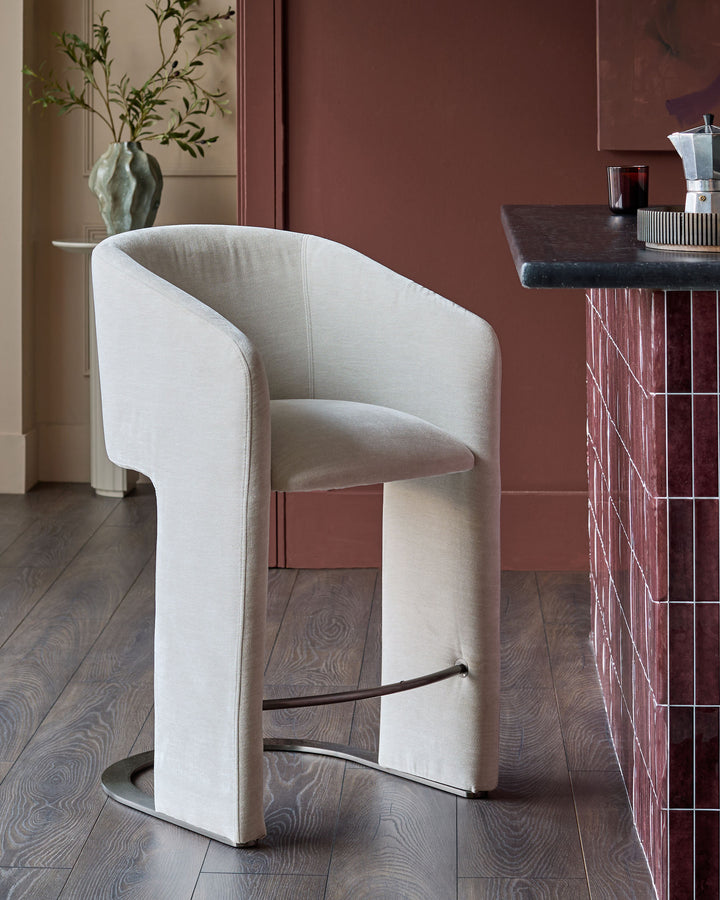 Leighton bar stool in natural grey fabric with black steel cantilever base, shown in modern interior setting.
