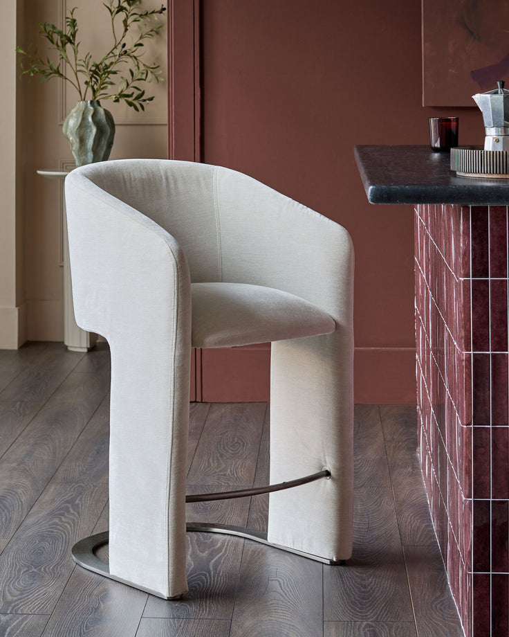 Leighton bar stool in natural grey fabric with black steel cantilever base, shown in modern interior setting.