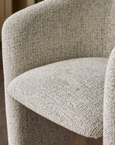 Close-up of grey fabric upholstery on a curved chair back and seat, showing woven textile detail.
