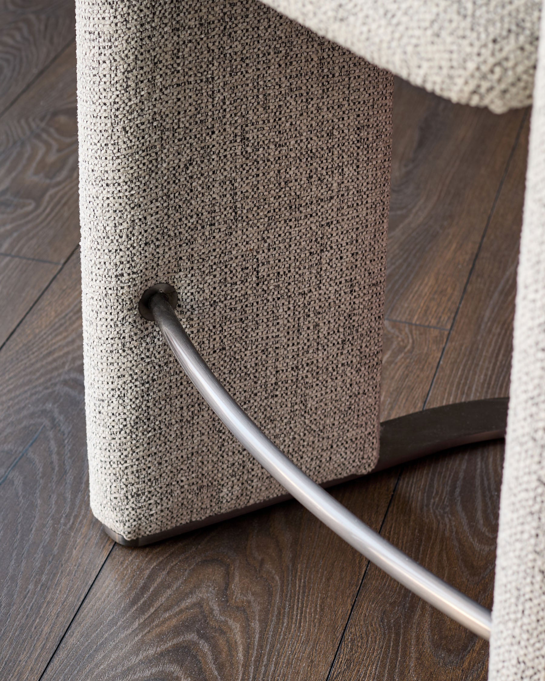 Grey fabric cantilever bar stool with chrome footrest and black steel frame detail.