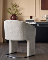 Leighton dining chair in grey chenille fabric with black chrome base, shown from rear angle in styled room setting.