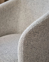 Close-up of grey chenille fabric on Leighton dining chair, showing textured weave and curved armrest detail.