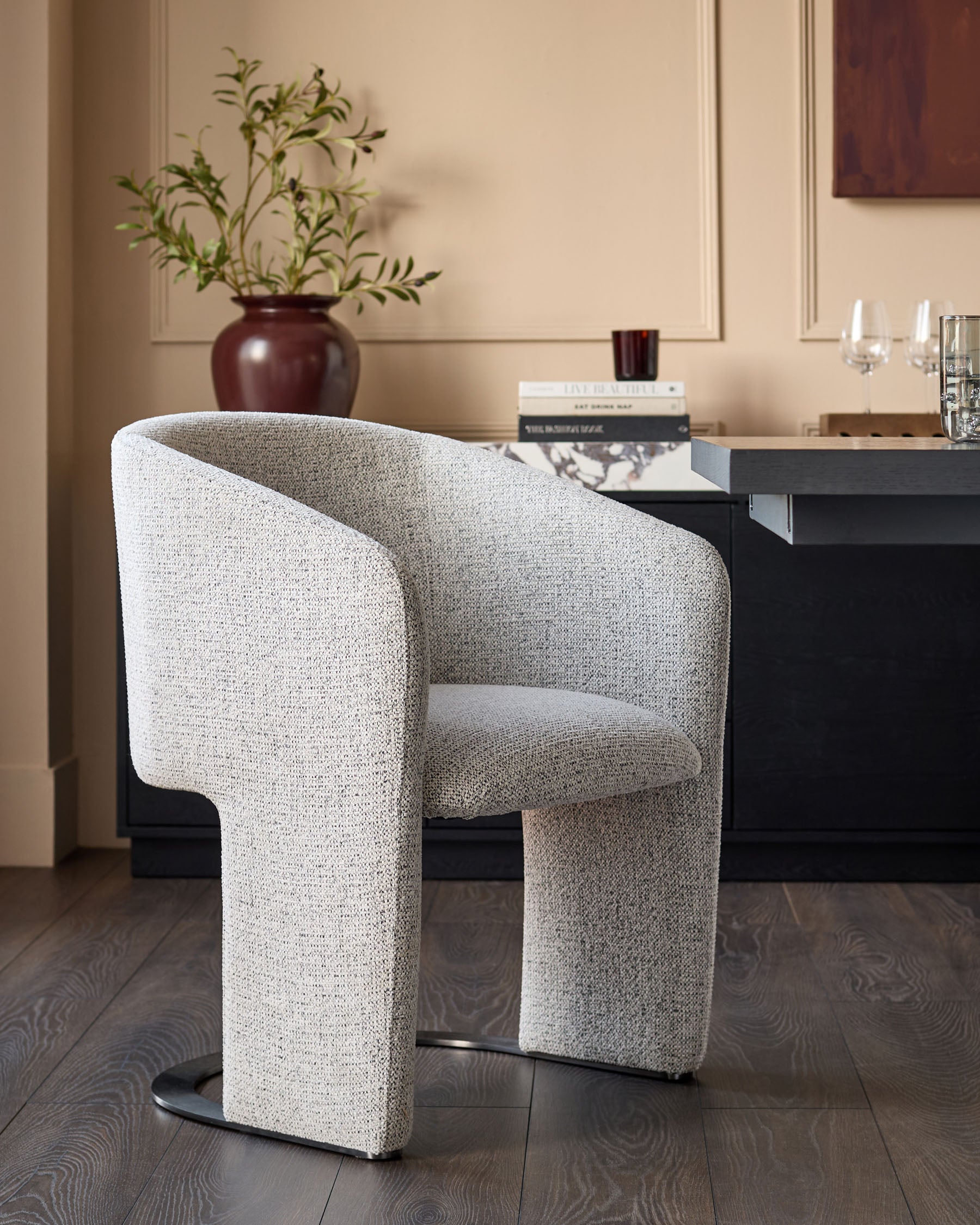 Leighton dining chair in grey chenille fabric with black chrome base, shown in a modern room setting.