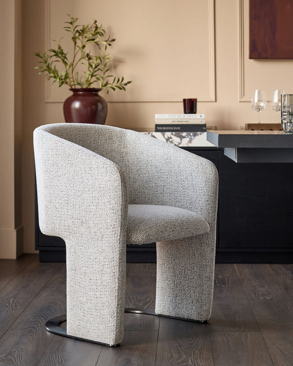 Leighton dining chair in grey chenille fabric with black chrome base, shown in a modern room setting.