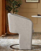 Leighton dining chair in natural grey chenille with black chrome curved base, shown from rear angle in styled interior setting.