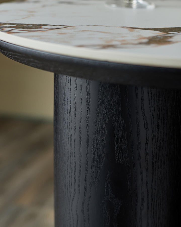 Close-up of a table with a marble top and a dark wood base, showcasing the texture and design detail.