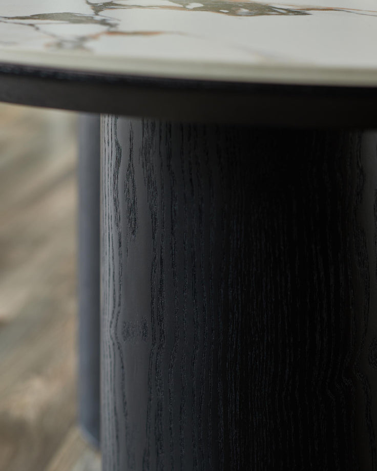 Close-up of a stylish, dark-stained wooden table leg and marble table top. Modern furniture design.