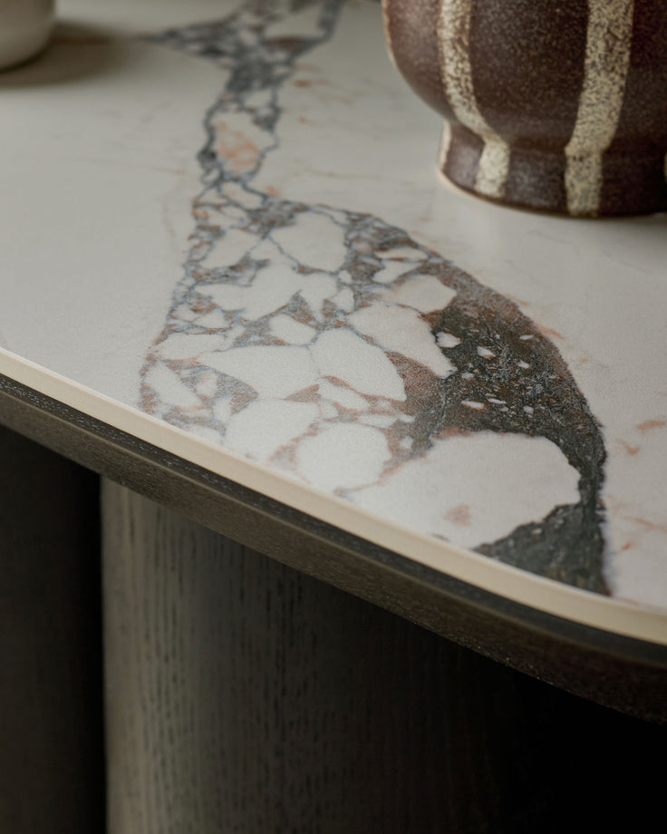 Lena console table in Calacatta white marble with dark wood base, showing close-up of veined marble top surface.