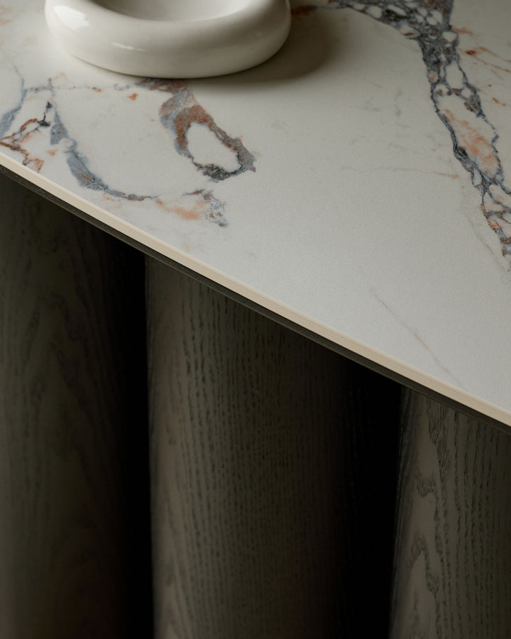 Lena console table with Calacatta white marble top and dark wood base, shown from angled side view.