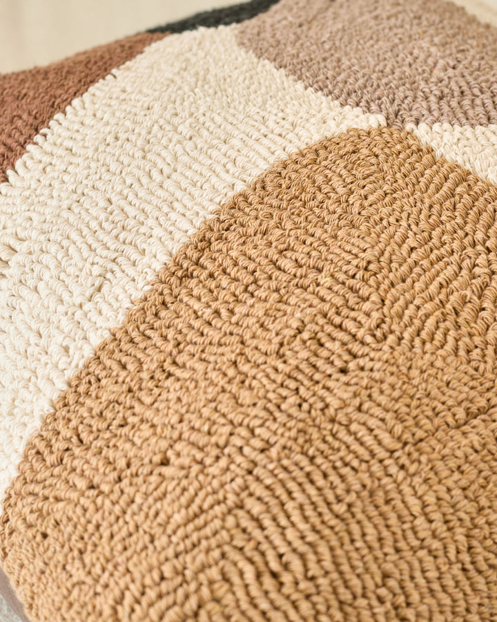 Close-up of Lennon cushion in natural showing textured woven fabric in cream and tan tones stacked together.