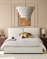 Bedroom featuring a boucle upholstered bed, bedside tables with lamps, and tiered pendant light.