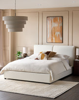 A stylish bedroom featuring a boucle bed, abstract art, and a textured rug, creating a cosy and modern atmosphere.