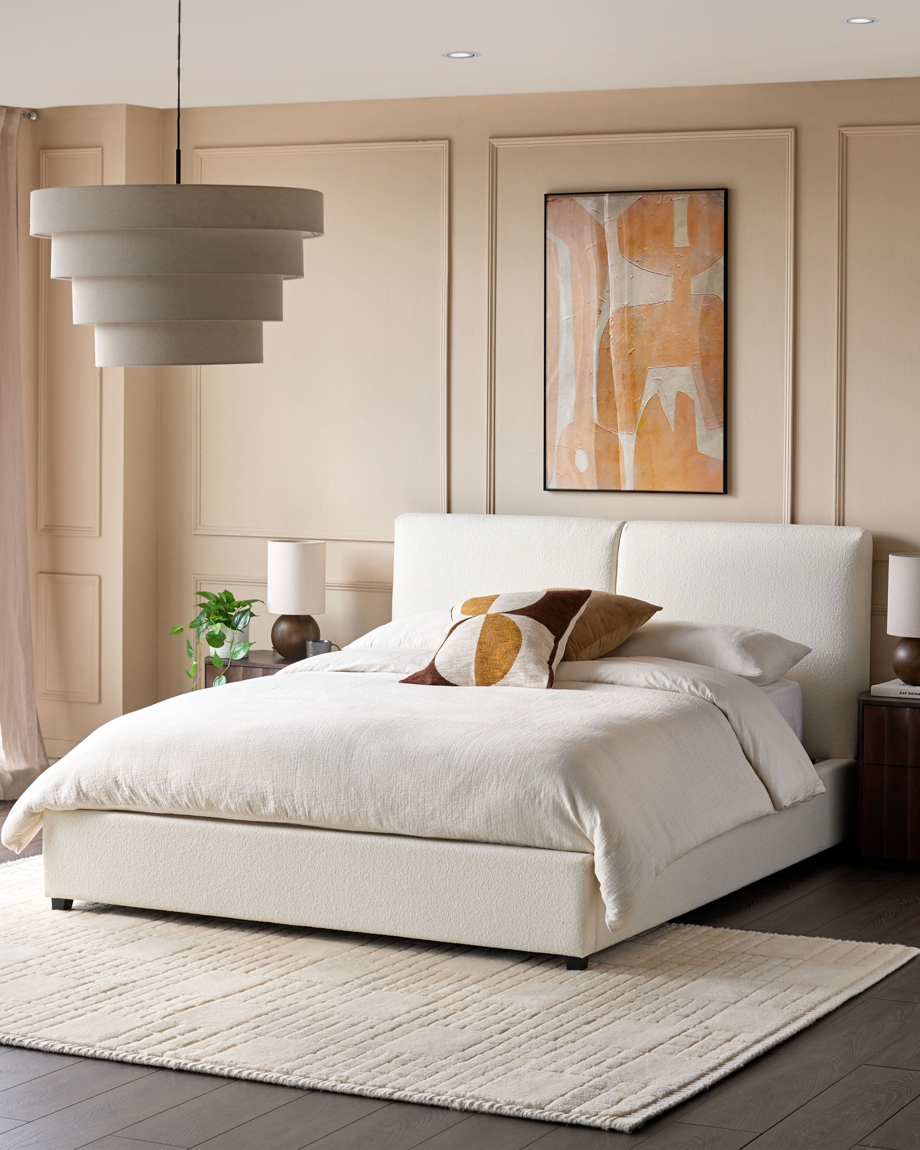 A stylish bedroom featuring a boucle bed, abstract art, and a textured rug, creating a cosy and modern atmosphere.