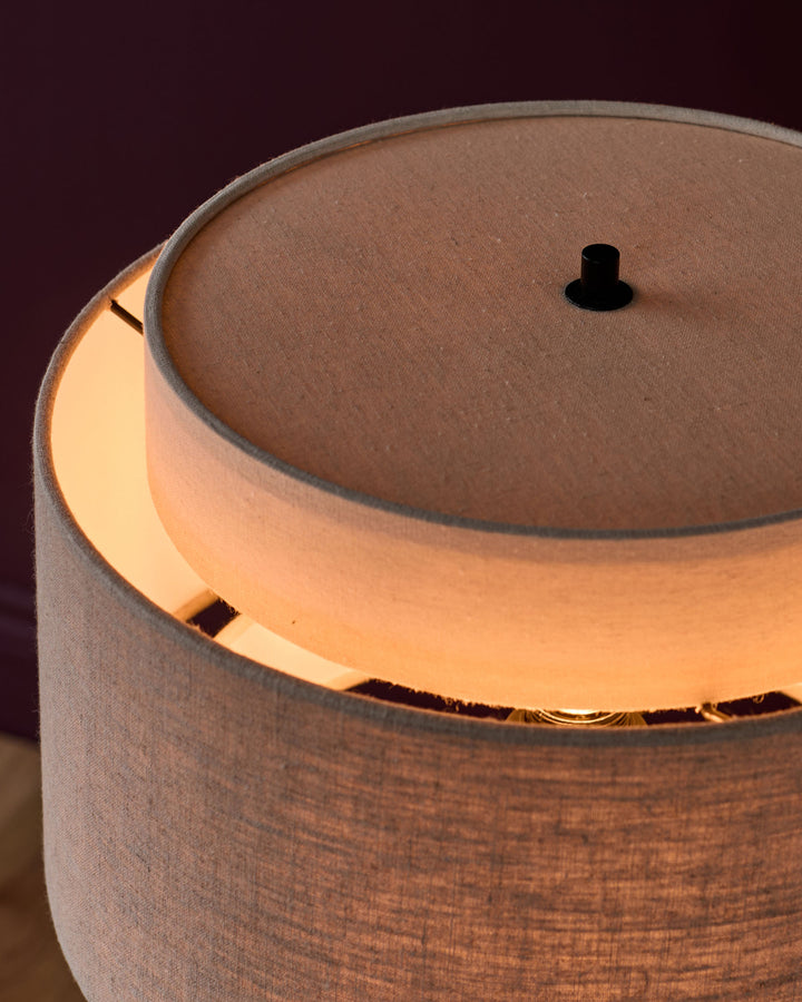 Leonie table light with natural linen shade and mocha base, shown lit from side angle with top finial visible.