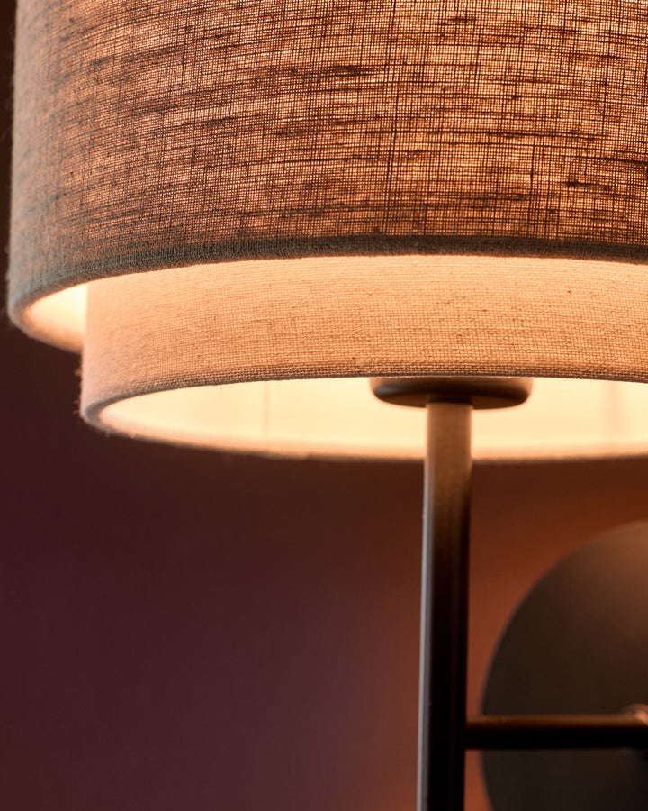 Leonie wall light with layered linen shade in natural and mocha tones, close-up detail view.