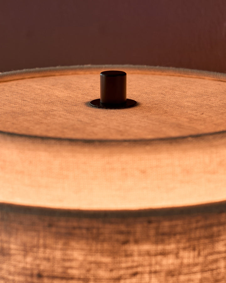 Leonie wall light with natural linen shade and mocha finial, shown from above detail view.