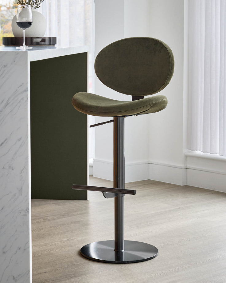 Lilah gas lift bar stool in olive green velvet with oval backrest, walnut wood accents, and black metal base.