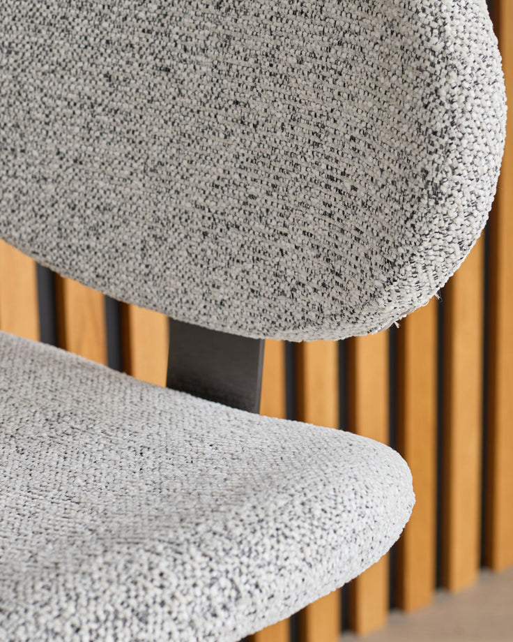 Lilah grey fabric bar stool with gas-lift mechanism, showing rounded seat and wooden leg base in close-up detail.
