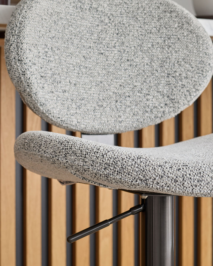 Grey fabric gas lift bar stool with curved seat and black metal base, shown from above.