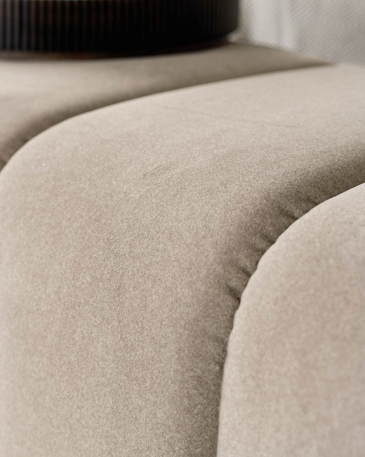 Lillian Bench in cream fabric, close-up detail of curved seating surface and upholstered texture.