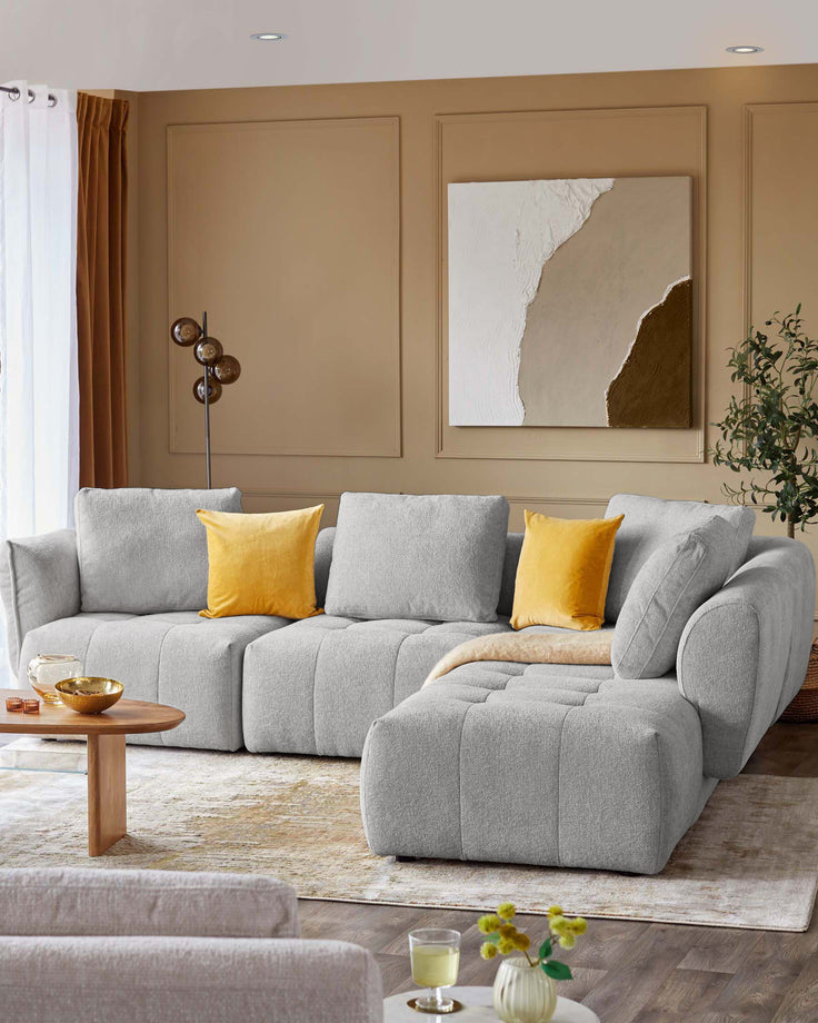 Lillian right corner chaise sofa in light grey weave, displayed in a warm beige living room with yellow accent pillows.