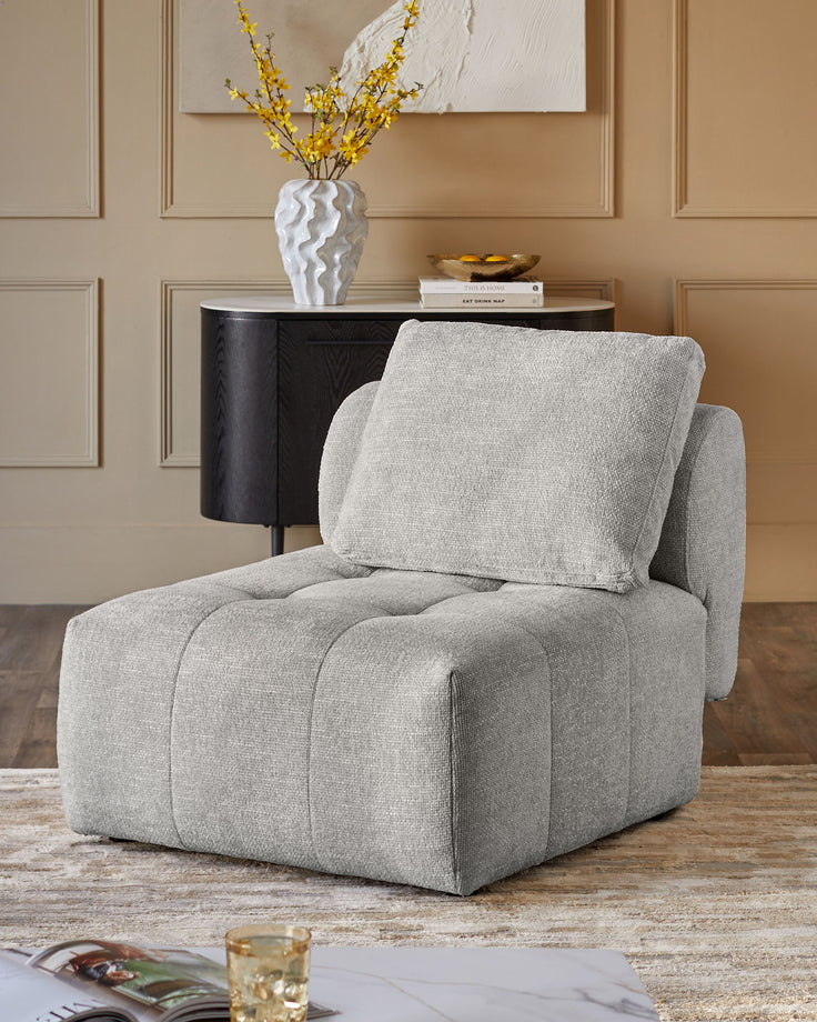 Lillian single-module sofa in light grey weave fabric, shown as a standalone chair with quilted seat and back cushion.