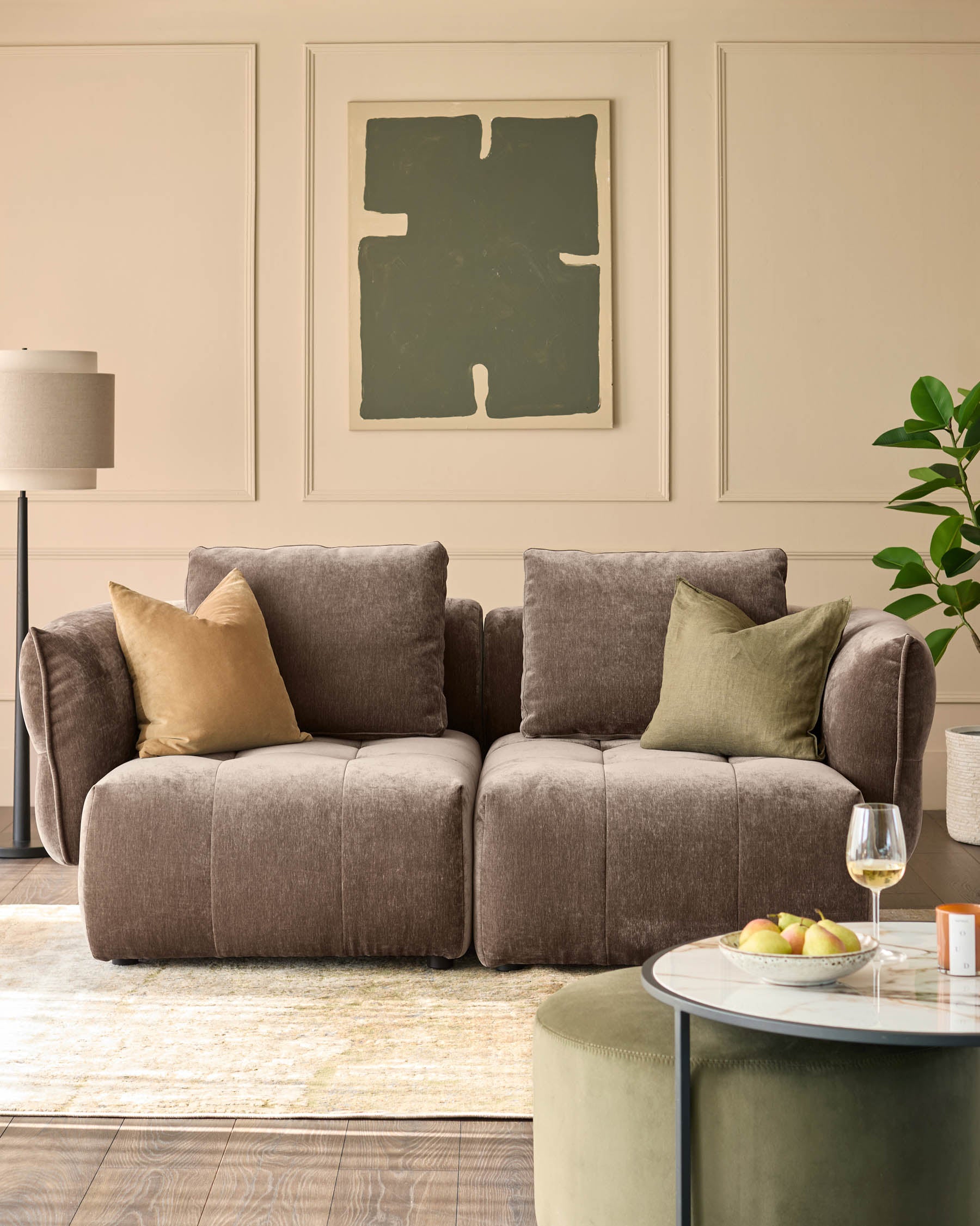 Stylish living room featuring a comfy sofa, patterned rug and round coffee table with a marble top and fruit bowl.
