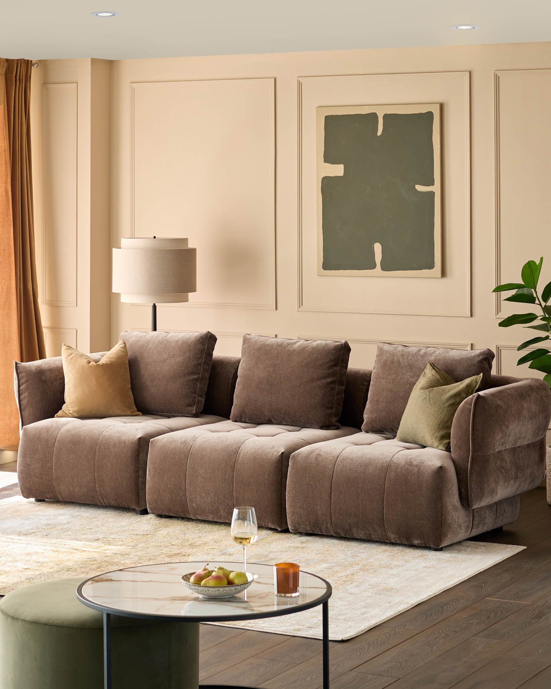 A stylish living room featuring a brown sofa, coffee table, and olive-green accents. Modern elegance at its finest.