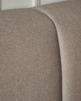 Lillian double ottoman bed in mocha fabric, close-up detail of curved headboard and seaming.