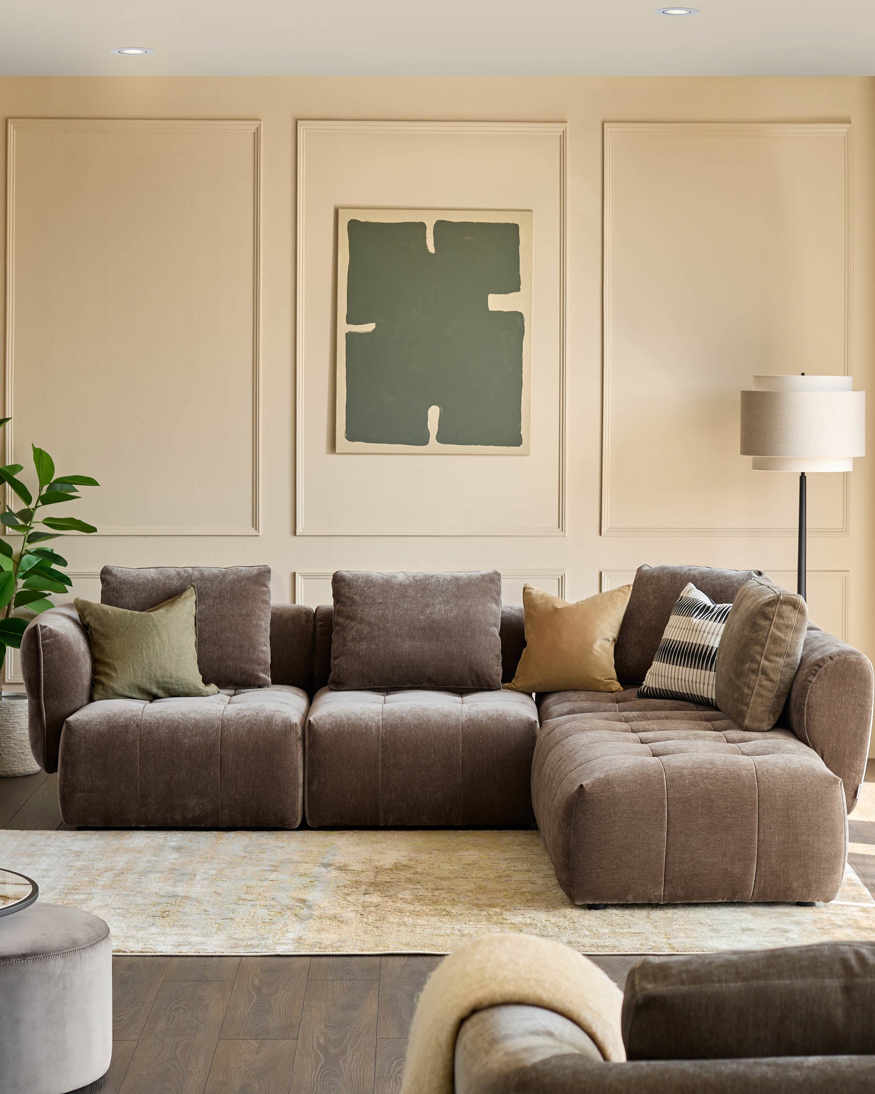 A stylish and comfy modular sofa with assorted cushions. A neutral colour palette adds to the room's relaxed vibe.