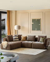 A luxurious brown corner sofa with textured cushions sits on a light rug in a well-lit living room.