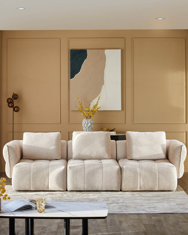 Contemporary living room featuring a cream sofa, abstract art, stylish coffee table and statement lighting.
