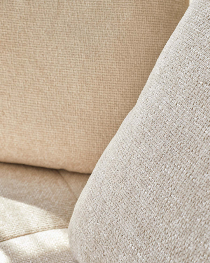 Close-up of textured beige upholstery and cushions, showcasing a cozy and inviting fabric perfect for modern living spaces.