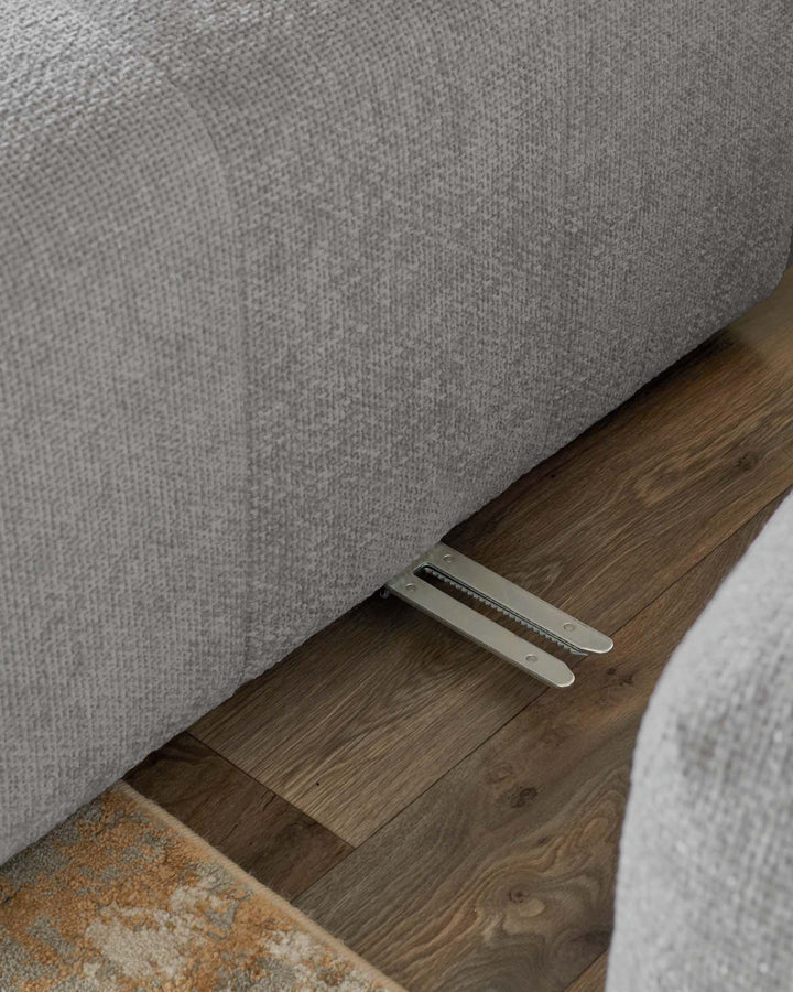 Lillian right corner chaise sofa in light grey weave, angled view showing curved arm and metal feet on wooden floor.