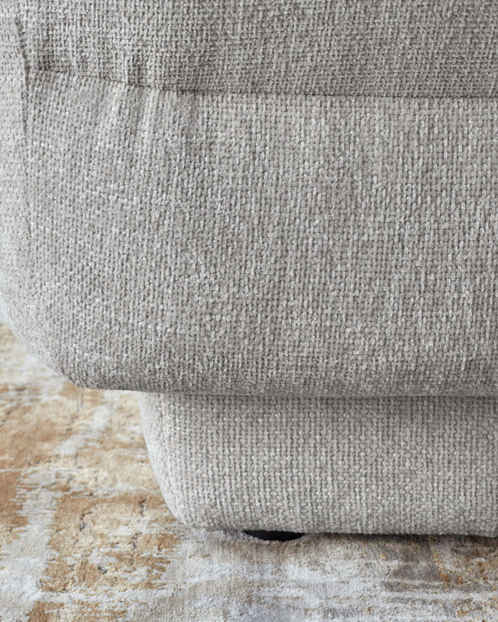 Lillian single module sofa in light grey weave fabric, shown at floor level highlighting the curved base and textured upholstery.