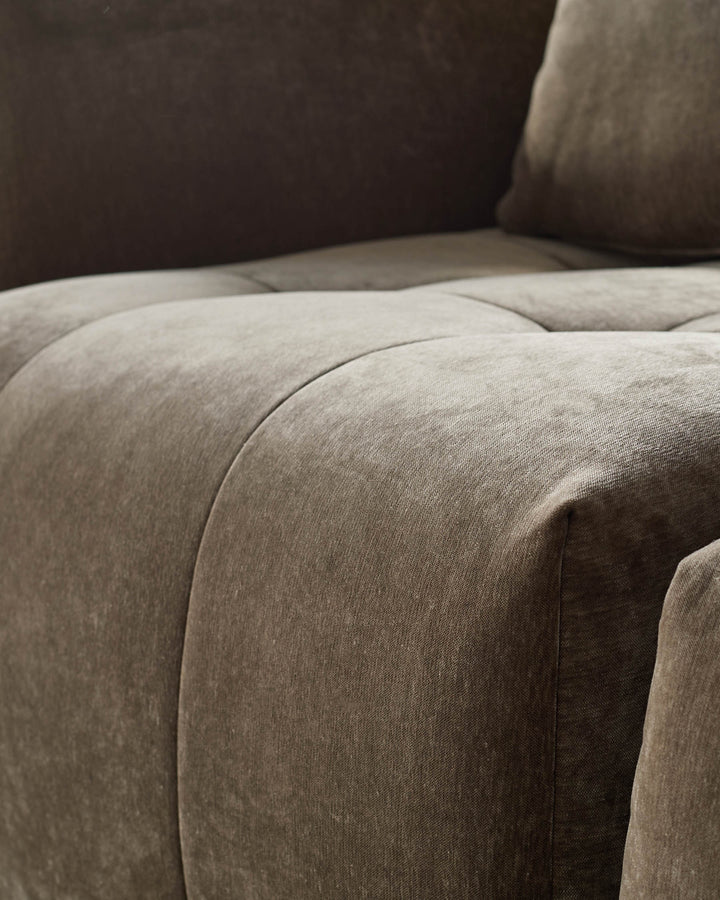 Close-up of a stylish, brown sofa with a soft, textured fabric. Perfect for lounging and adding a touch of elegance to any living space.