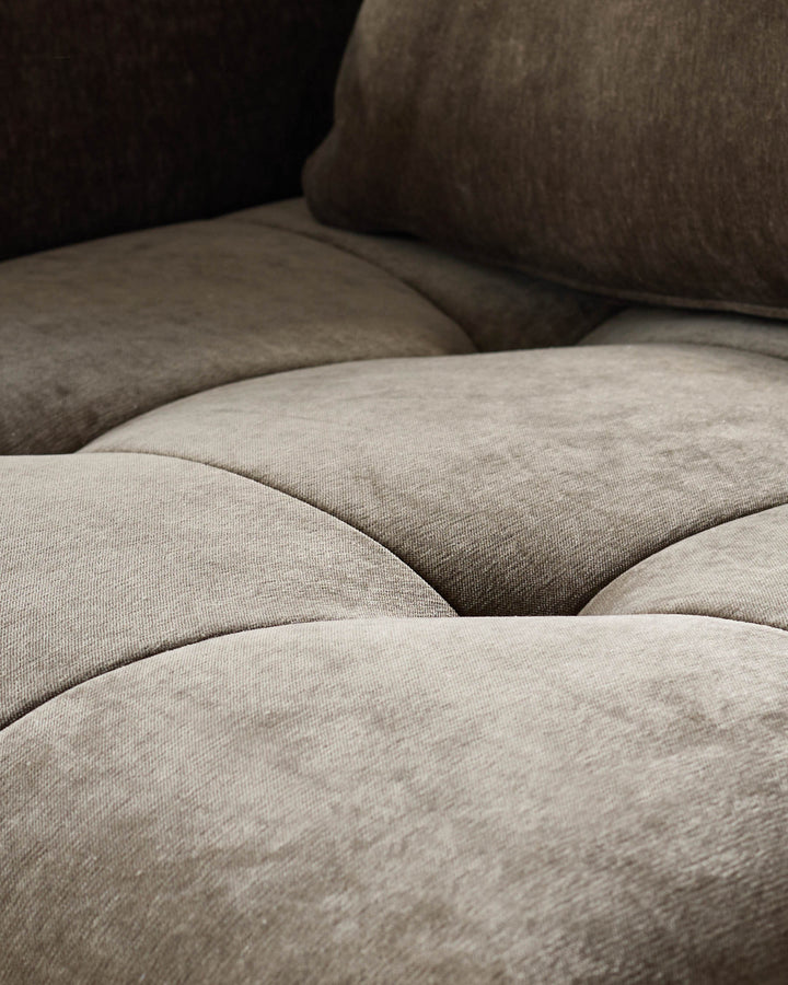 Close-up of a plush, button-tufted sofa or couch, showcasing its texture and depth. Luxurious comfort and style for your living space.