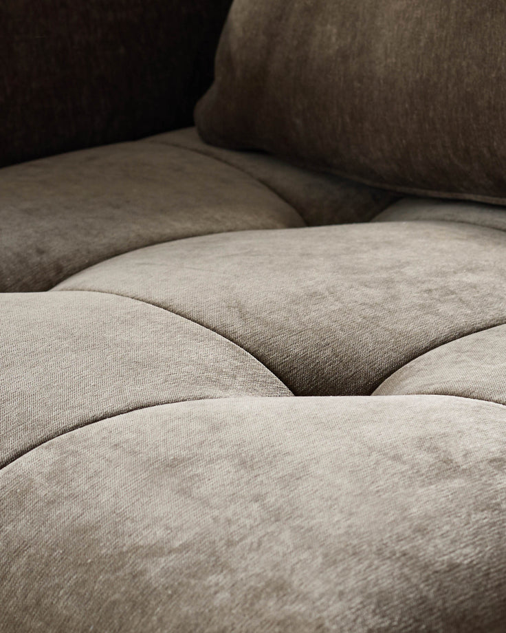 Close-up of a plush, button-tufted sofa or couch, showcasing its texture and depth. Luxurious comfort and style for your living space.