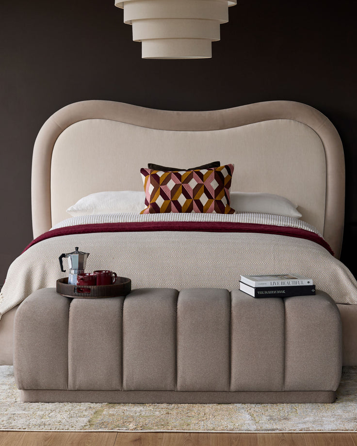 Lillian bench in mocha fabric with vertical channel quilting, shown at foot of bed in styled bedroom setting.