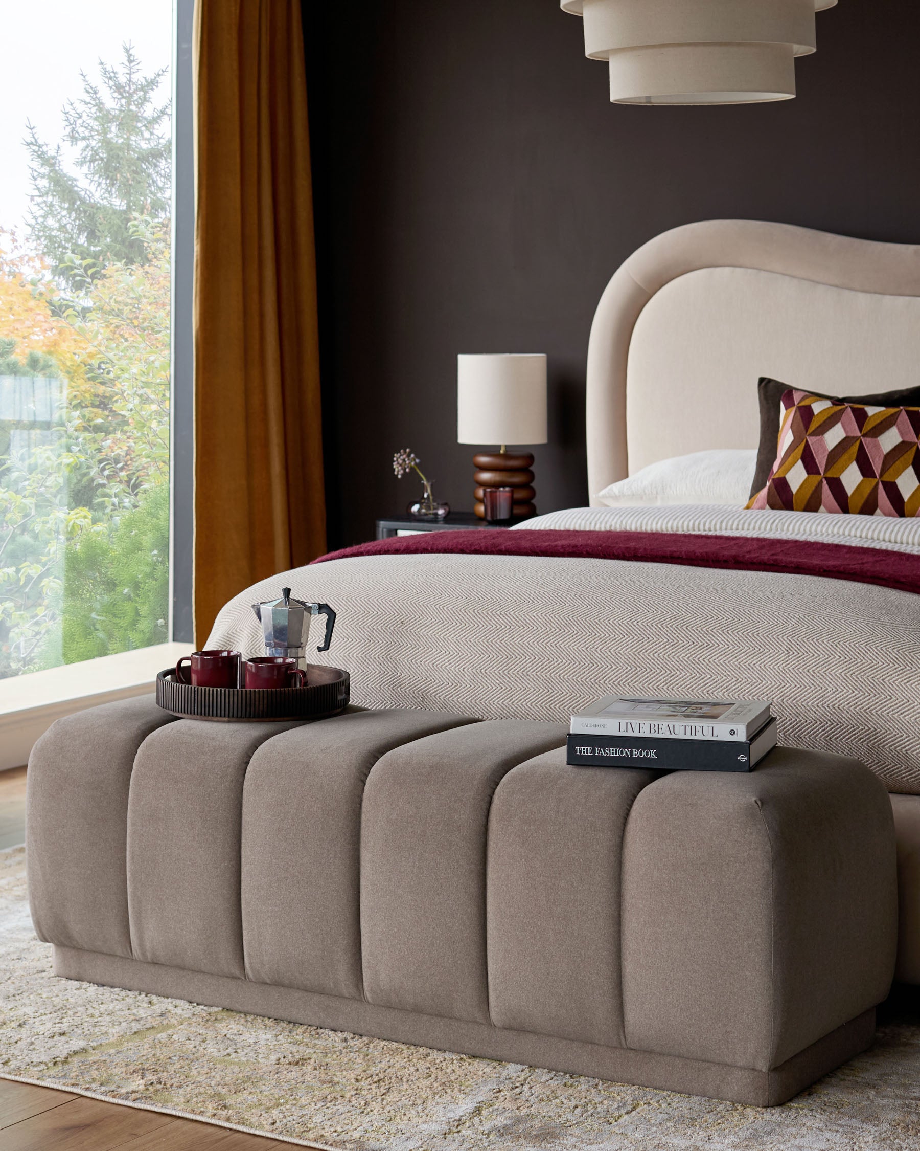 Mocha upholstered bench with vertical channel quilting at foot of bed in modern bedroom setting.