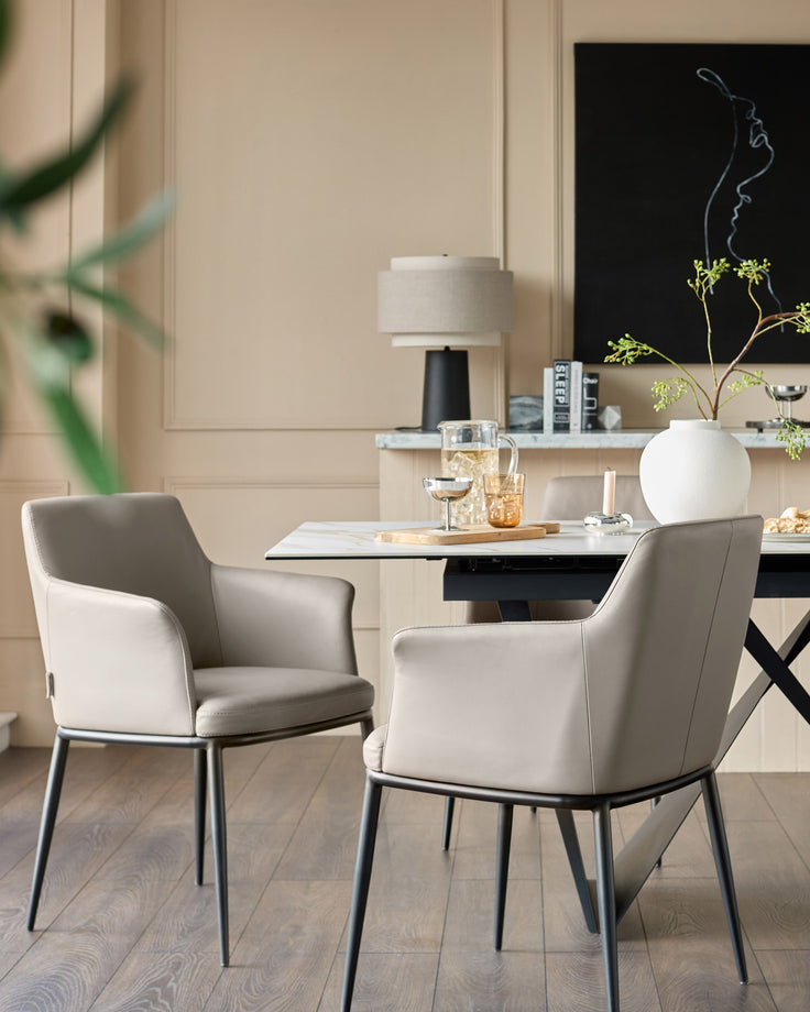 Logan dining chair in light grey real leather with black metal legs, shown in modern dining room setting.