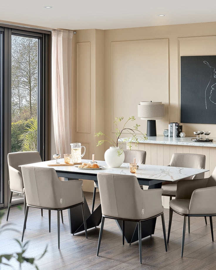 Logan dining chair in light grey real leather with black metal legs, shown in a modern dining setting.