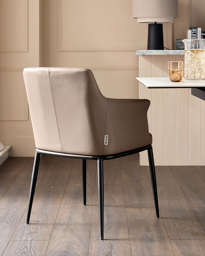 Logan dining chair in mocha leather with black metal legs, shown from rear angle in a modern interior setting.