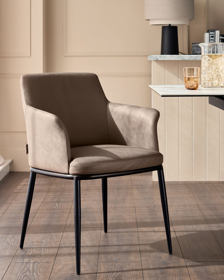 Logan dining chair in mocha leather with black metal legs, shown in a contemporary room setting.