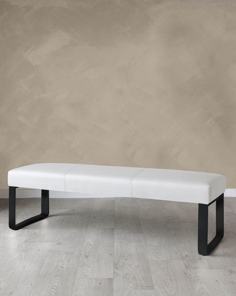 Modern minimalist white upholstered bench with black metal legs on a light wooden floor against a textured beige wall.