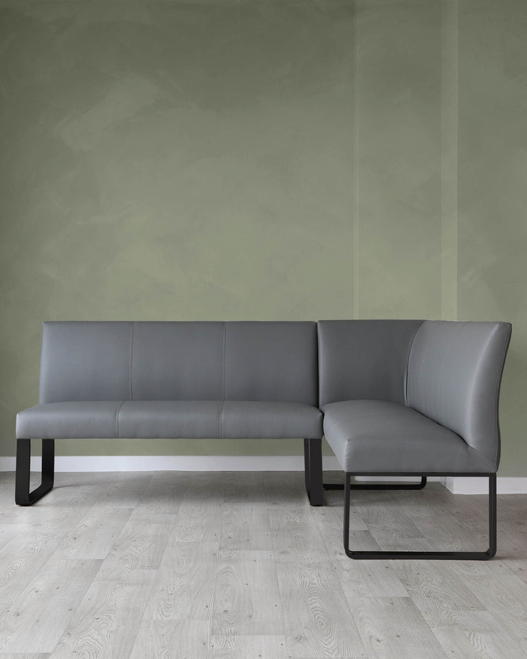 Modern L-shaped sectional sofa with grey upholstery and minimalist black metal legs. The sofa has a sleek silhouette with clean lines and is positioned in a room with a muted green wall and light wood flooring.