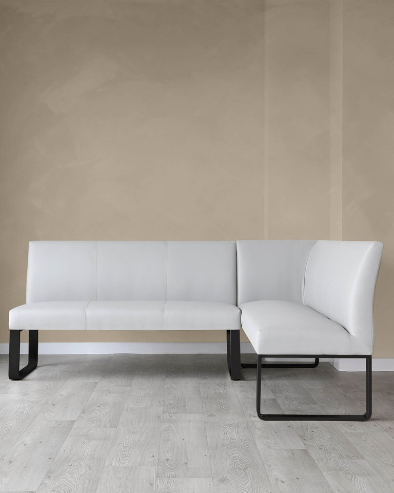 Modern L-shaped sectional sofa with white upholstery and minimalist black metal legs, featured in a room with light beige walls and pale wood flooring.