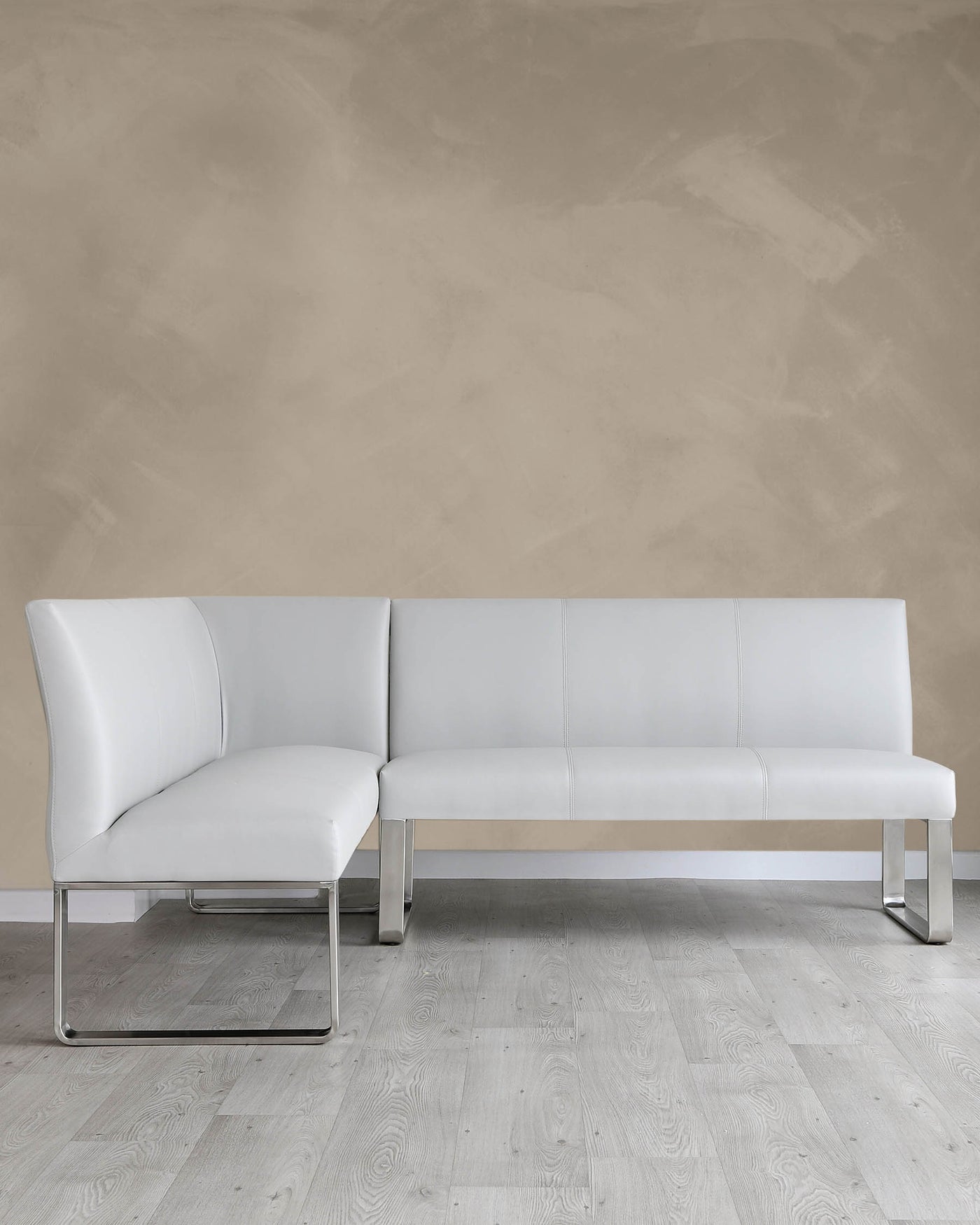 Modern white leather sectional sofa with clean lines and chrome metal legs, featuring a chaise lounge on one end.