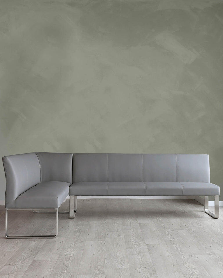 Modern minimalist sectional sofa with sleek lines, upholstered in light grey leather, featuring a chaise lounge on one end and chrome-plated metal legs.