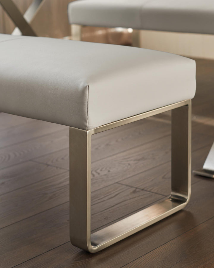 Close-up of a grey leather bench seat with a square gold coloured metal base, part of a larger seating arrangement.